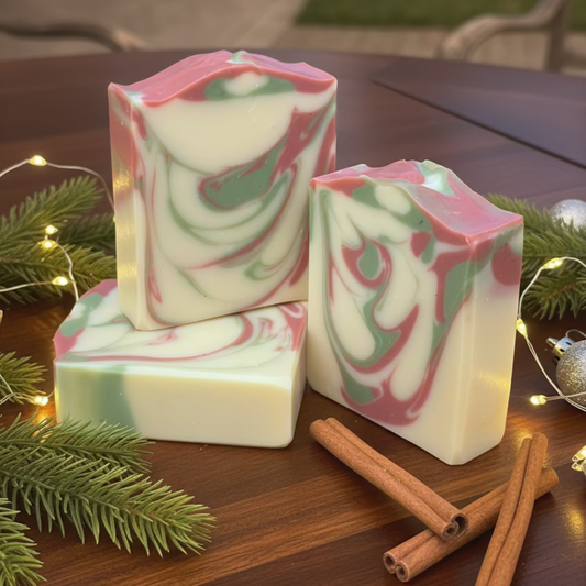 Swirl-patterned soap bars on a wooden surface with Christmas decorations