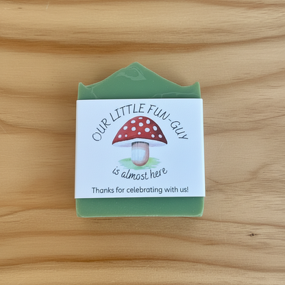 Green soap bar with a mushroom design and text on a wooden surface